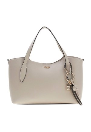 Sac à main Guess beige avec deux poignées, logo doré, porte-clés attaché avec cadenas et pompon, sur fond blanc uni.