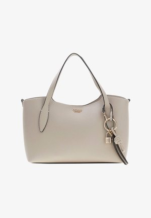 Sac à main Guess beige avec deux poignées, logo doré, porte-clés attaché avec cadenas et pompon, sur fond blanc uni.