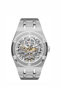 Zilveren roestvrijstalen horloge met een skeleton-dial die complexe tandwielen toont. Voorzien van gepolijste accenten en een robuust, hoekig kastontwerp.