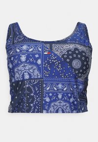 Blue crop top featuring a patchwork design of paisley and floral patterns. Made from a smooth fabric with a scoop neckline and wide straps.