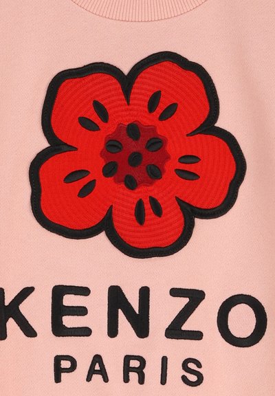 Sweat-shirt rose avec un grand design de fleur rouge brodé, entouré de contours noirs, accentué par un texte noir lisant "KENZO PARIS."