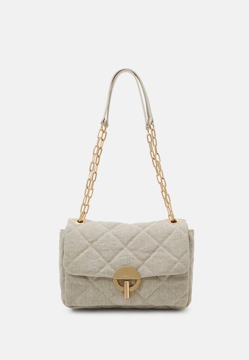 Sac à main matelassé beige avec une bandoulière chaîne dorée et une fermeture à tourniquet ronde dorée sur le rabat avant.