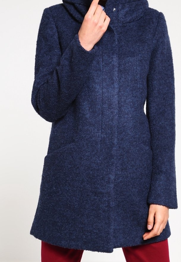 Cappotto in lana blu navy con finitura testurizzata, dotato di cappuccio, due tasche frontali e una linea dritta che termina sopra il ginocchio.
