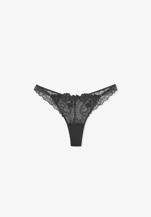 Perizoma in pizzo nero, con ricami floreali, bordi ondulati e un pannello posteriore liscio. Leggero e progettato per un uso delicato.