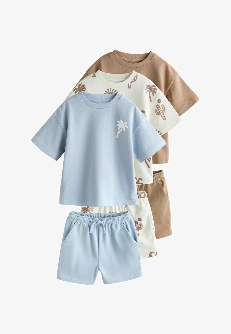 Tres conjuntos para niños pequeños con camisetas de manga corta y pantalones cortos: azul claro con palmera, blanco con estampado de cactus marrón, y marrón sólido.
