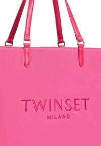 Borsa tote rosa con logo impresso "TWINSET MILANO", realizzata in materiale testurizzato. Presenta lunghe spalline rosa lisce con dettagli in oro.