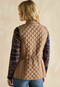 Braune, gesteppte Weste mit hohem Kragen, tailliertem Gürtel und subtiler glanz; zeichnet sich durch ein Rautenmuster und leichten Stoff aus.