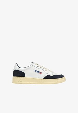 Sneaker bassa bianca e nera con suola beige, punta traforata, chiusura con lacci e logo "Autry" con bandiera americana sul pannello laterale.