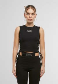 Top corto senza maniche nero con logo bianco, caratterizzato da dettagli di laccio laterali. Realizzato in materiale a coste con un design aderente.