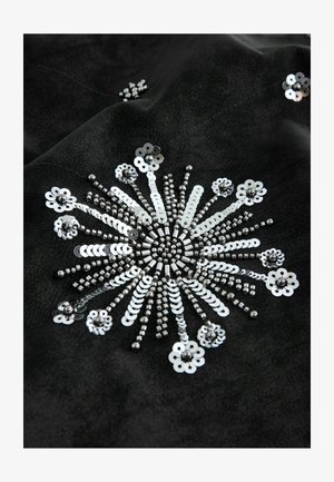 Black fabric featuring intricate silver sequins arranged in a sunburst pattern, with varying sizes of beads and flower-like designs embedded.