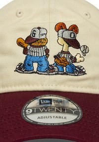Căciulă bej ajustabilă cu bor bordeux, decorată cu personaje de desene animate brodate care joacă baseball, purtând căciuli și uniforme cu dungi.