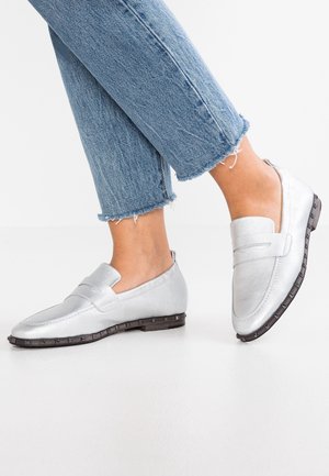 Sølvfarvede læder loafers båret med cropped blå jeans på en hvid baggrund, viser side- og vinklet frontvisning.