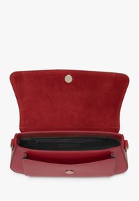 Rote Ledertasche mit glattem Außenmaterial, Wildlederinnenfutter und Magnetverschluss. Verfügt über zwei Fächer und eine Reißverschlusstasche innen.