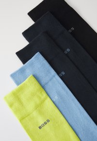 Öt pár zokni: fekete, sötétkék, világoskék és élénk sárga. Ribbed anyagból készült, a "BOSS" márkanevével a tetején.