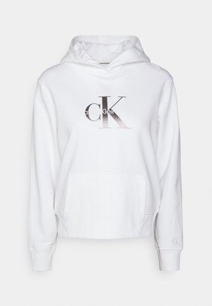 Bílá mikina s kapucí a přední kapsou na klokanku, na hrudi s kovovým logem "CK Calvin Klein", žebrované manžety a malé logo na levém rukávu.
