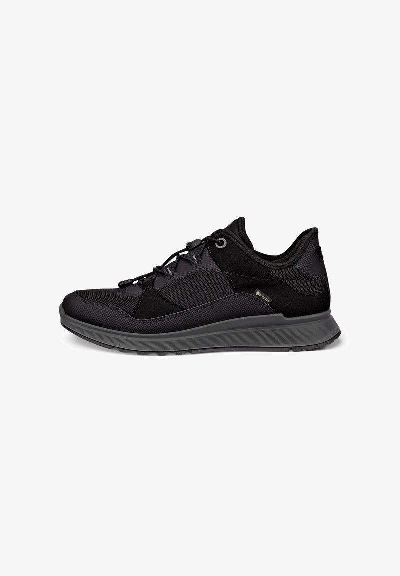 Sort atletiksneaker med mesh- og ruskindspaneler, snorlås, tyk tekstureret sål og Gore-Tex mærke på siden.