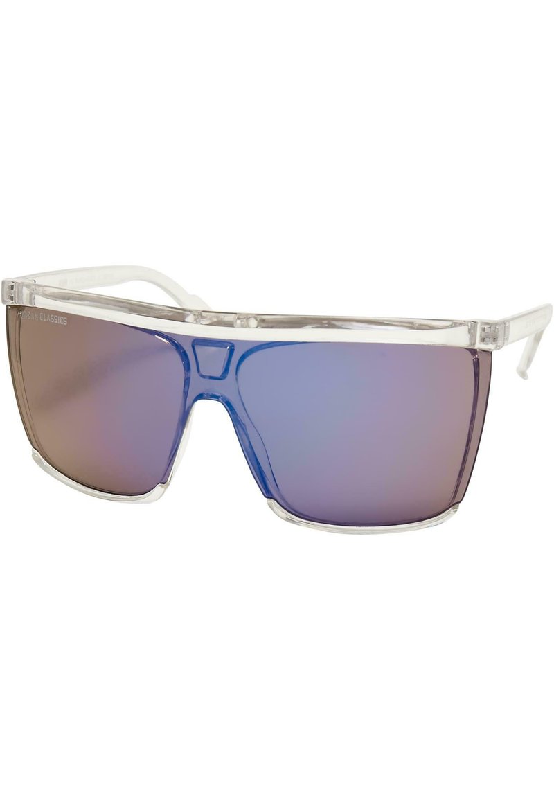 Lunettes de soleil avec une monture en plastique transparent et des verres dégradés bleus, présentant une grande forme angulaire pour une couverture totale et un design minimaliste.