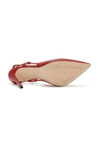 Scarpa rosso in pelle con tacco alto, punta affilata, cinturino sottile alla caviglia e suola beige liscia con un motivo testurizzato.