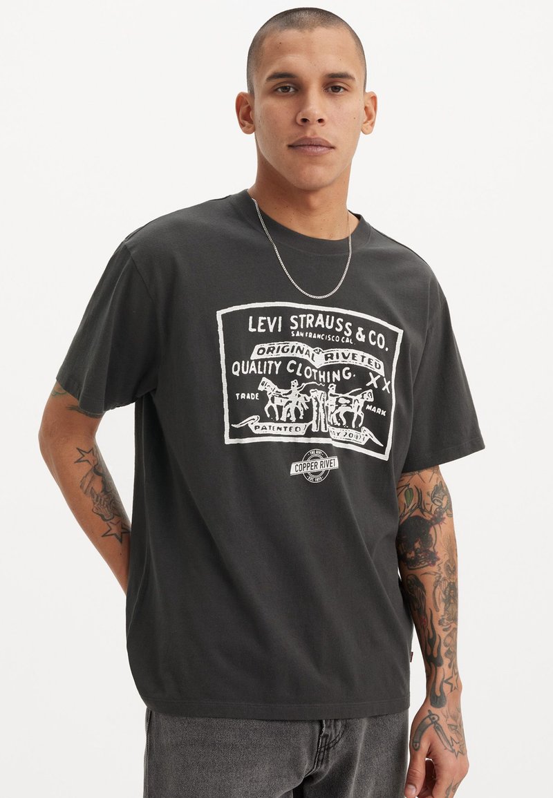 T-shirt noir en coton pour homme avec un graphique vintage du logo blanc Levi Strauss, représentant des chevaux et du texte, col rond, coupe décontractée et manches courtes.