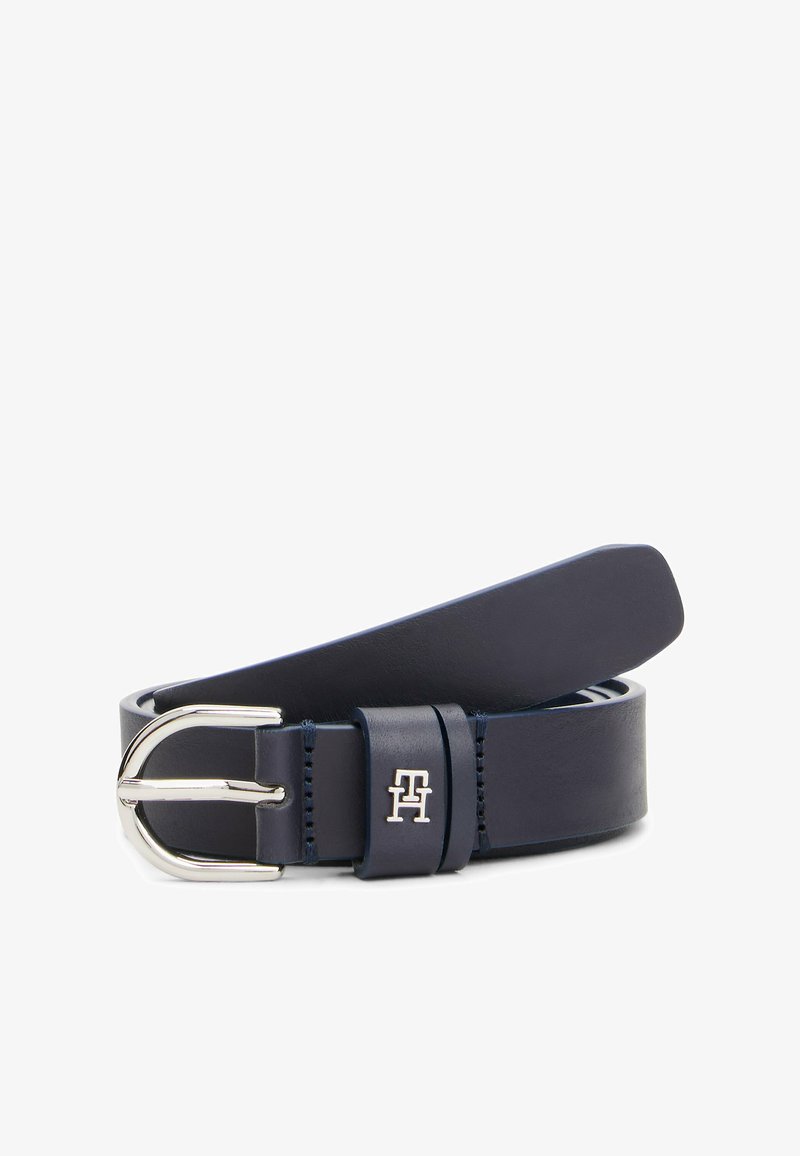 Ceinture en cuir bleu marine avec une boucle en métal argenté, présentant un petit logo en accent et une texture lisse et propre. Design classique et polyvalent.