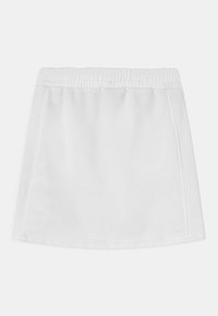 Vit kjol med elastisk midja, tillverkad av mjukt tyg. Enkel design med rak form och synliga sömmar längs sömmarna.