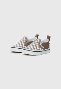 Detské slip-on tenisky s hnedobielym kostkovaným vzorom, bielymi gumovými podrážkami a ušami na päte na jednoduchom pozadí.