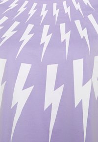 Camiseta púrpura con un patrón repetido de rayos blancos. La tela parece suave con una textura ligera y un ajuste relajado.