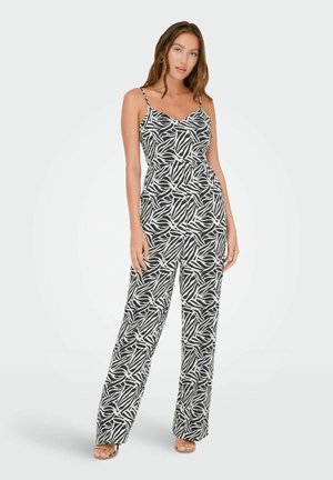 Combinaison noire et blanche avec un motif de feuillage, dotée de bretelles spaghetti, d'une taille cintrée et de pantalons larges. Texture de tissu lisse.