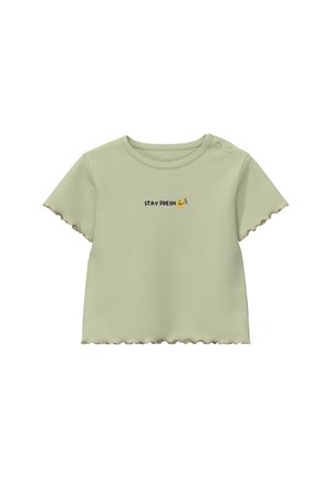 Jasnozielona prążkowana koszulka z krótkim rękawem, z falistymi krawędziami i dwoma guzikami na ramionach, z napisem "STAY FRESH" oraz ikoną uśmiechniętej twarzy.