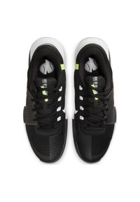 Scarpe da ginnastica nere con tomaia in mesh, accenti bianchi e inserti verde neon. Suola texturizzata con scanalature prominenti e lacci.