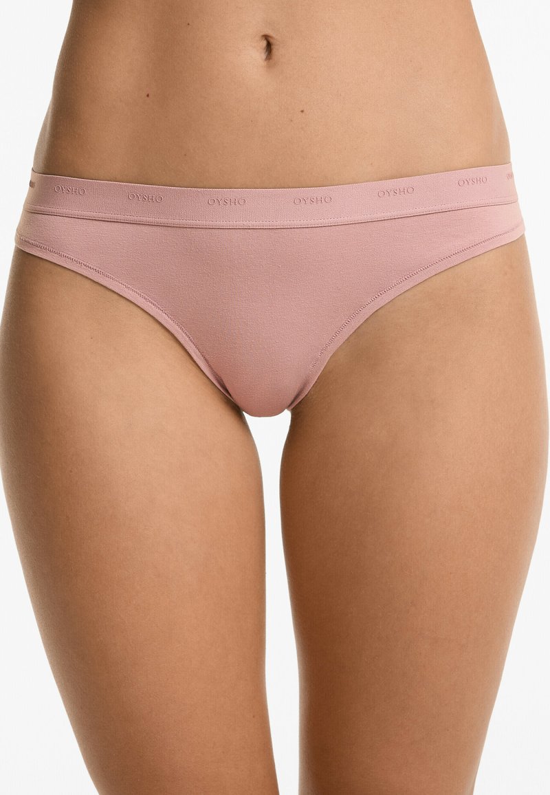 Világos rózsaszín bikini alsó, puha, textúrált anyagból, kényelmes derékpánttal, amelyen finoman az "OYSHO" márkaneve van bélyegezve.