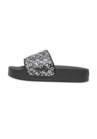 Sandale slide noire avec semelle épaisse et large bride recouverte d'un texte blanc répétitif "BUFFALO" et un petit logo Buffalo en métal sur la bride.