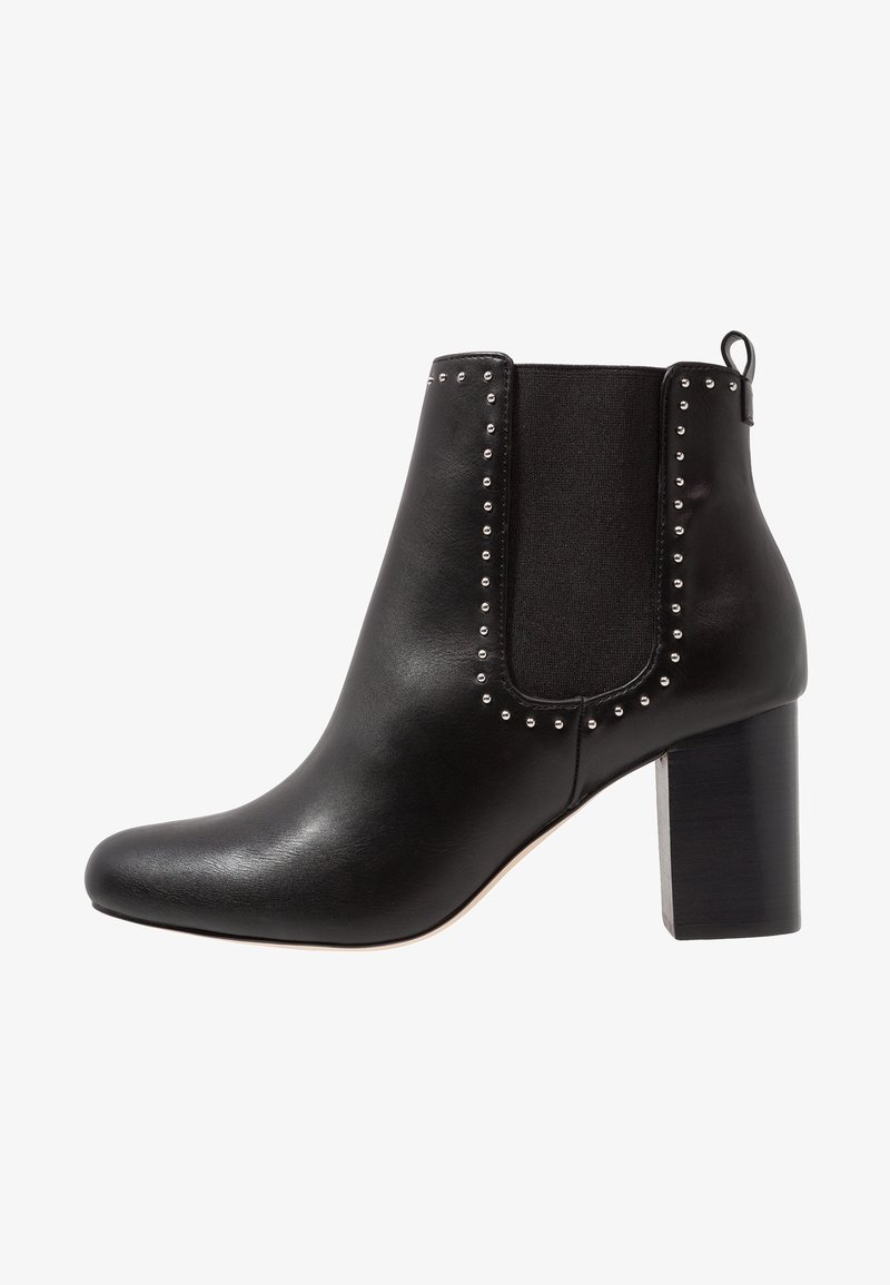 Černá kotníková bota z kůže, s texturovaným elastickým panelem, stříbrnými cvočky podél okraje a robustním černým podpatkem.