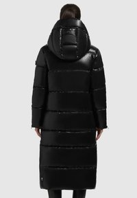 Schwarze Pufferjacke mit langem Design, glänzender Textur, übergroßer Kapuze und horizontalen Nähten sowie einem Label auf der Rückseite.