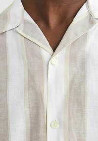 Camisa de manga corta con rayas horizontales en color beige claro y blanco, confeccionada en una tela texturizada, con cuello de punta y cierre de botones.