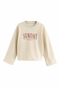 Lys beige sweatshirt lavet af blødt materiale, med rund halsudskæring og boxy form. Har rødt trykt tekst "SUNDAY siden 1982" foran.