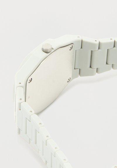 Λευκό πλαστικό ρολόι με μεταλλική πίσω πλάκα στερεωμένη με τέσσερις βίδες και λευκό τμηματικό λουράκι που ταιριάζει.