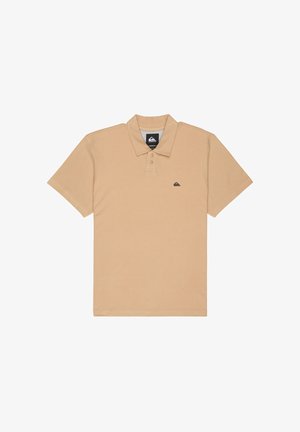 Polo beige en coton avec col, trois boutons au niveau du cou, manches courtes et petit écusson logo sur la poitrine gauche.