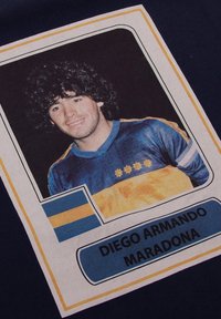 Marineblauw T-shirt met een portret van een man met krullend haar, die een blauw en geel sportshirt draagt. Inclusief een landvlag en tekstlabel.