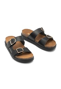 Czarne sandały z faux skóry z dwoma regulowanymi paskami, złotymi klamrami, korkową wkładką oraz teksturowaną czarną gumową podeszwą.