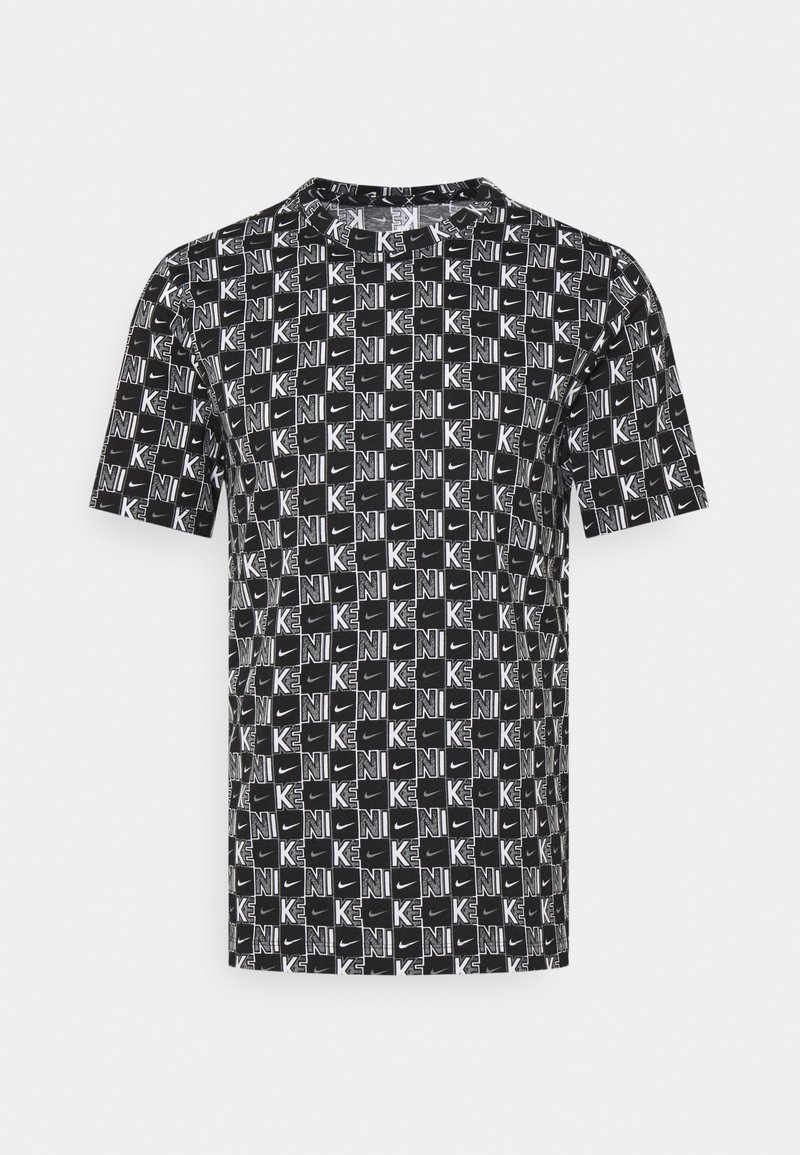 Lyhythihainen musta t-paita, jossa on valkoinen graafinen kuvio, joka kattaa koko paidan ja jossa on "K" ja "NIKE" -logot. Pyöreä pääntie, kevyt kangas.