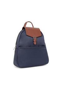 Zaino in nylon blu navy con patta in pelle marrone e chiusura a fibbia, dotato di tasca frontale e maniglia superiore. Texture liscia con dettagli minimi.