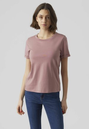 Lys rosa kortermet T-skjorte med rund hals og avslappet passform. Mykt bomullsmateriale med subtil tekstur. Kombinert med mørkeblå jeans.