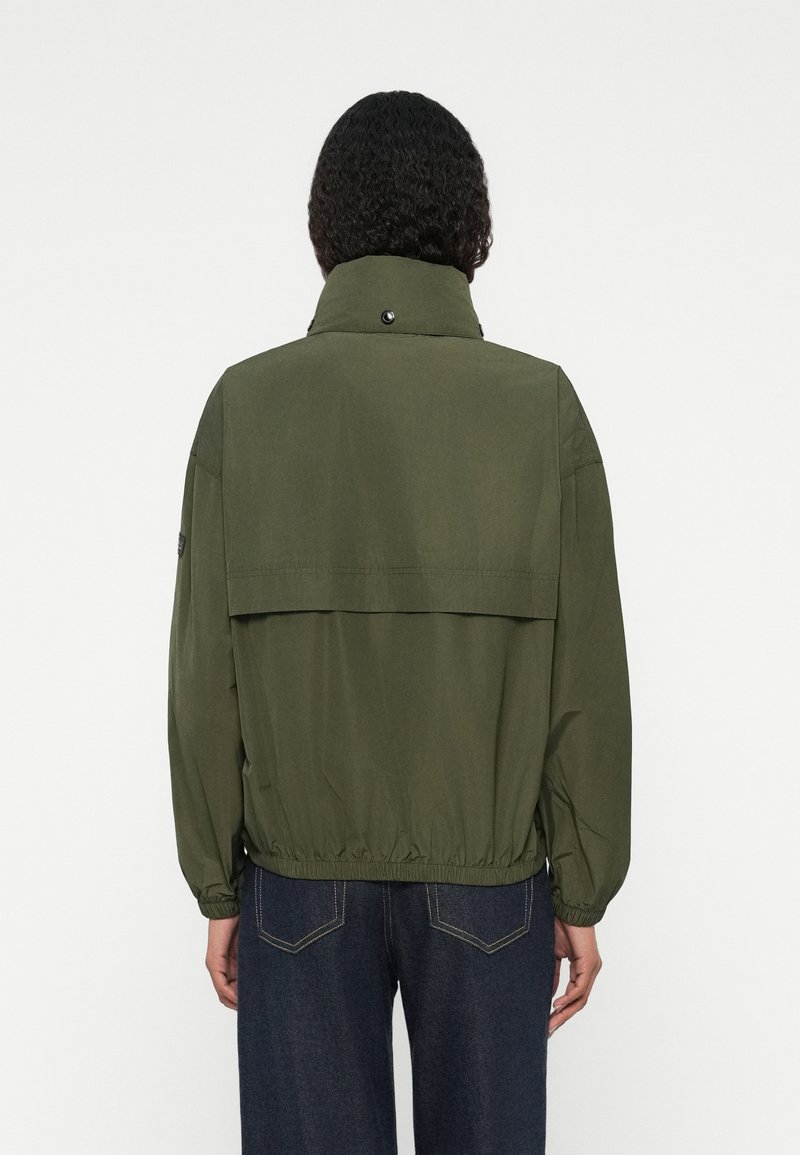 Olivgrüne Jacke mit hohem Kragen, elastischem Taillenbund und lockerer Passform. Verfügt über eine Klappe auf der Rückseite und Knopfakzente am Kragen.