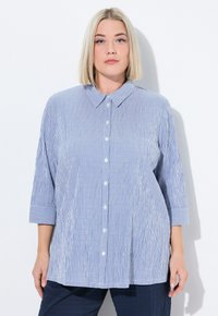 Camicia a righe blu e bianche con colletto e maniche a tre quarti, caratterizzata da una vestibilità rilassata e una texture liscia.