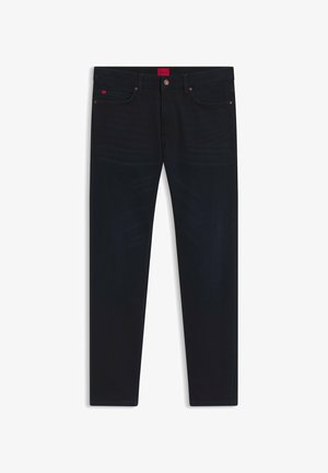 Dark blue jeans made of denim, featuring a straight leg design, five pockets, copper-tone hardware, and a red logo patch on the waistband.