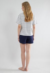 Gestreept katoenen T-shirt in wit en marineblauw met korte mouwen, gecombineerd met marineblauwe shorts. De stof lijkt zacht en lichtgewicht.