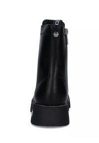Stivale alla caviglia in pelle nera con superficie liscia, suola in gomma spessa e chiusura con zip sul retro con finiture in metallo.