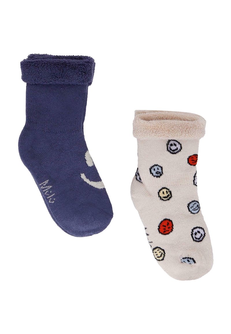 Dwie pary skarpetek: lewa w ciemnym niebieskim z wzorem uśmiechniętej buzi, prawa w jasnym beżu z wielokolorowymi uśmiechami; obie mają miękkie wywinięte mankiety.