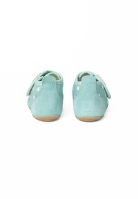 Lichtblauwe suède schoenen met een gladde textuur, witte stippen en een klittenbandsluiting. Rubberzool met een ronde vorm.